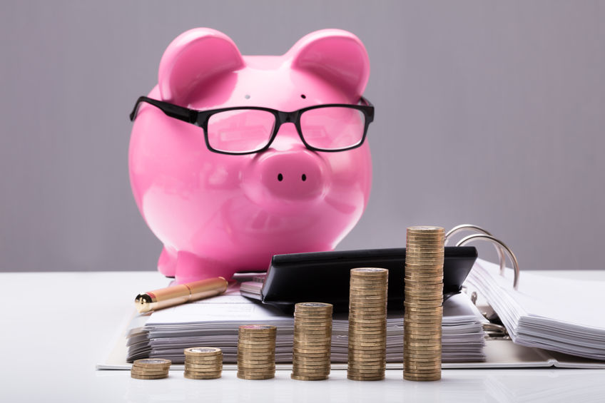 Stacked Coins And Document In Front Of Piggy Bank Stacked Coins And Document In Front Of Piggy Bank